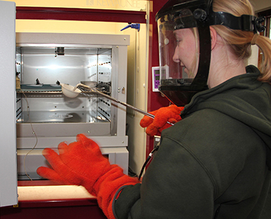 Allison Knockle, a City of North Liberty water lab analyst,
removes a sample from a furnace heated to 550 degrees Celsius
for a volatile solids test during a laboratory certification.